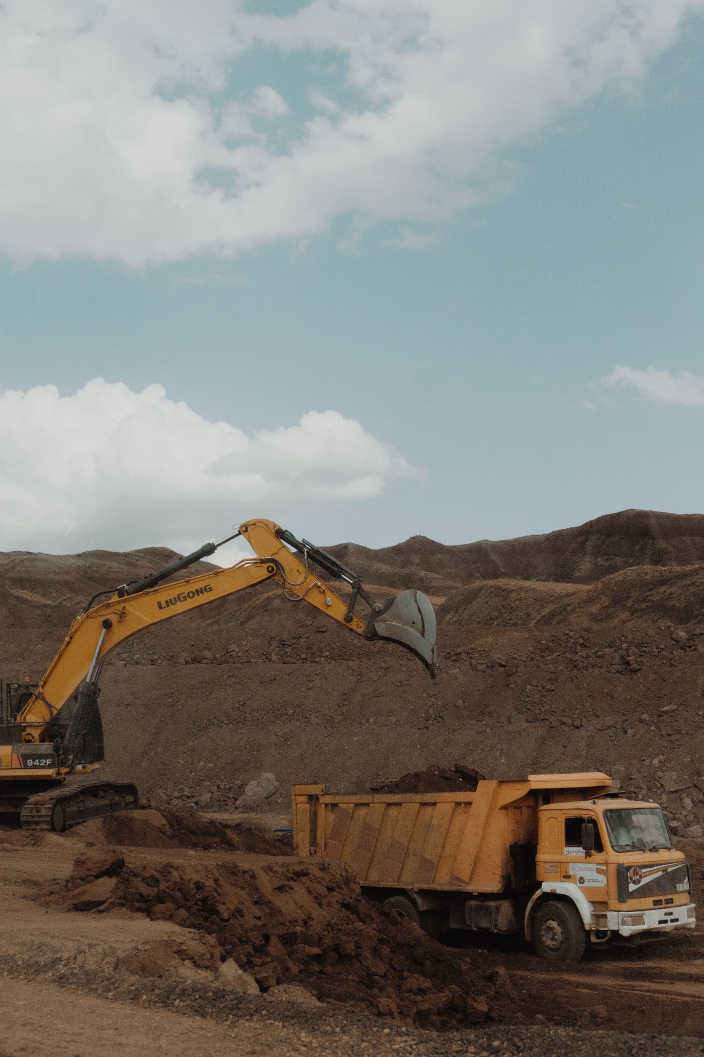 Faena minera a rajo abierto con excavadora y camión de extracción